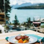 Steak and wine with a view of Maligne Lake and surrounding mountains